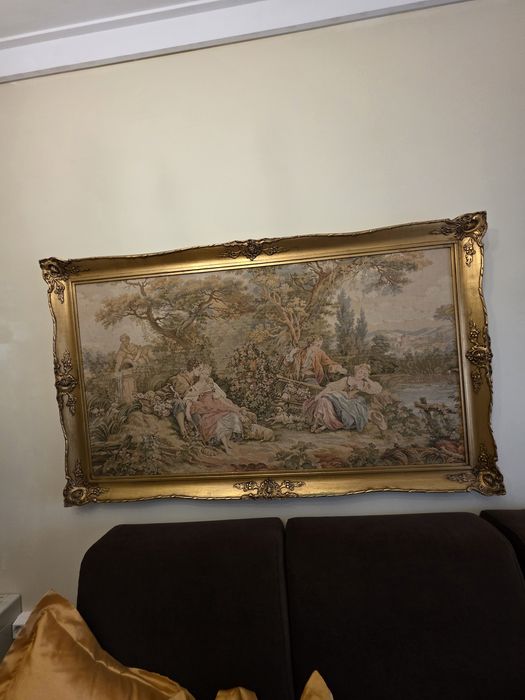 Quadro de tapeçaria emoldurado com uma cena pastoral.