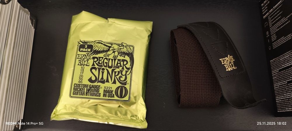 Pasek gitarowy oraz dwa komplety oryginalnych strun Ernie Ball 3221