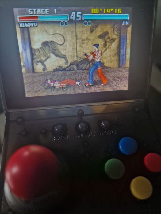 consola portátil retro a correr o jogo Tekken Advance.