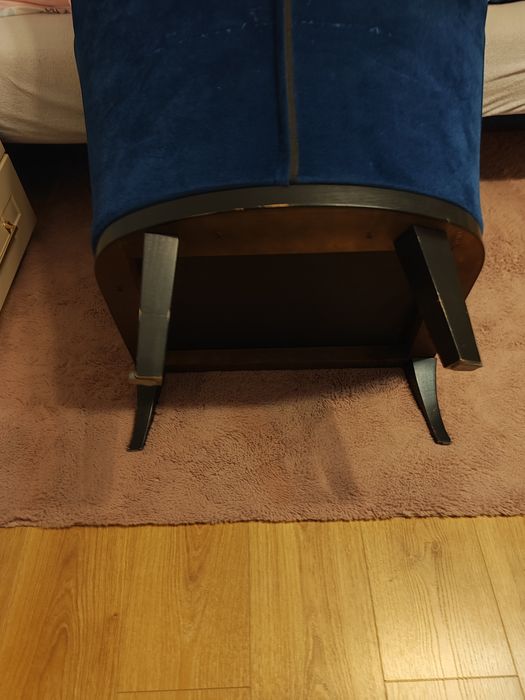 fotel uszak z aksamitnym obiciem w kolorze granatowym.