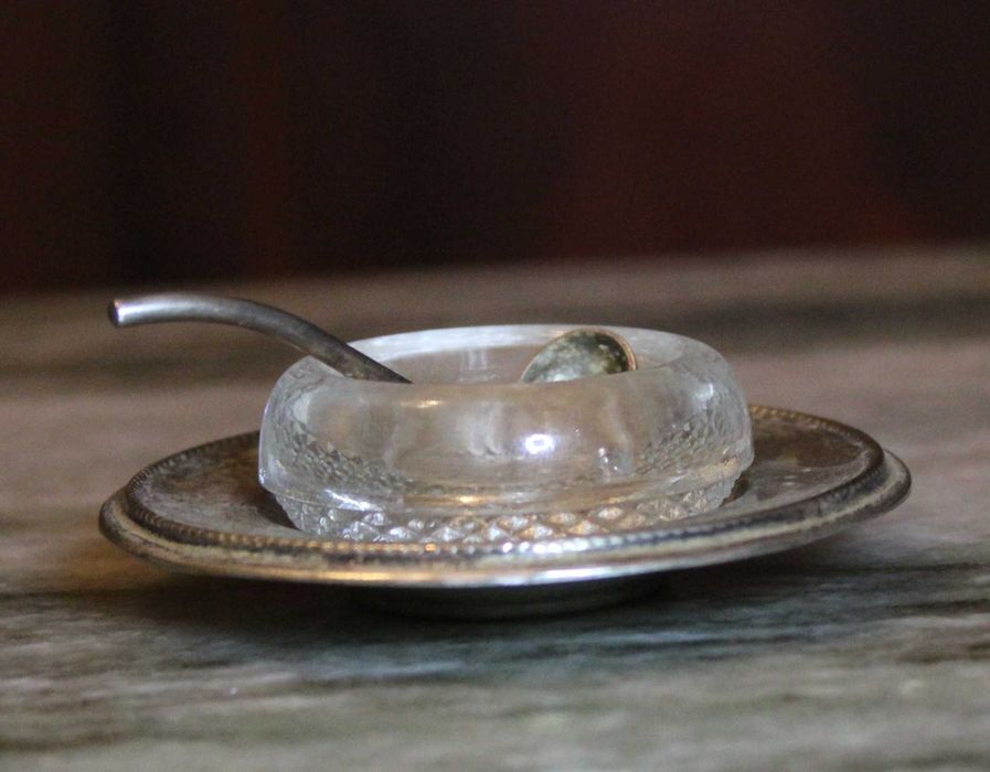 Saleiro de cristal com prato e pequena colher em casquinha, marcado.