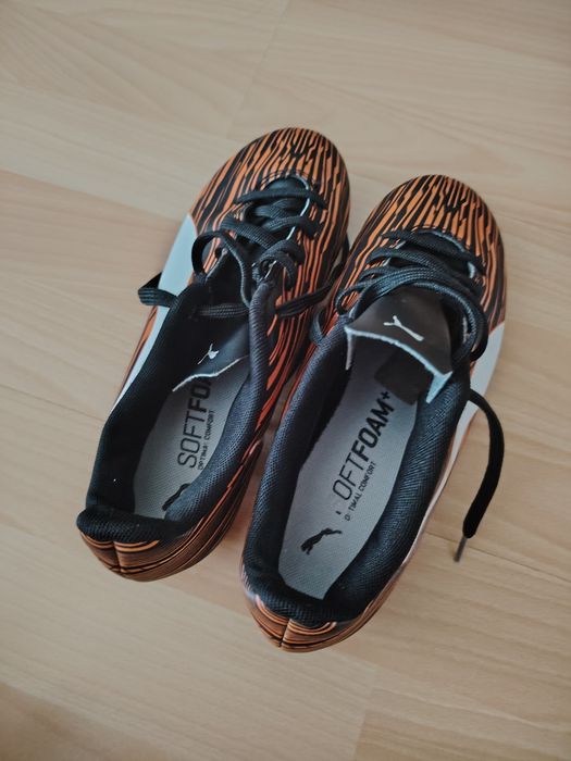 Chuteiras puma pretas e laranja