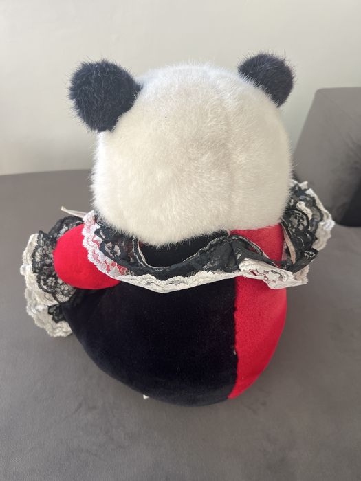 Maskotka pandy ubrana w czerwono czarny strój