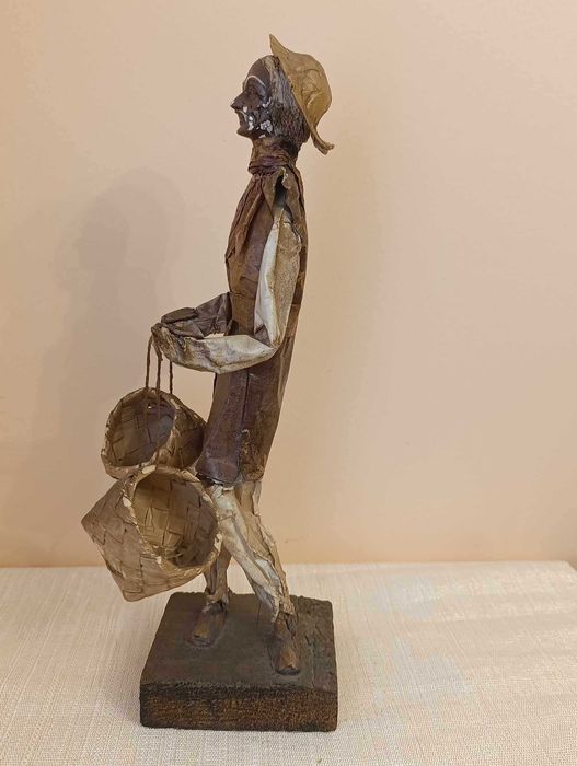 Figura de artesanato homem em papel maché com cestos