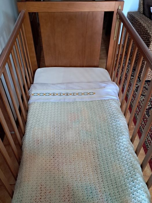 Cama de bebé  co colchão  e almofada de levantamento de  cabeceira.