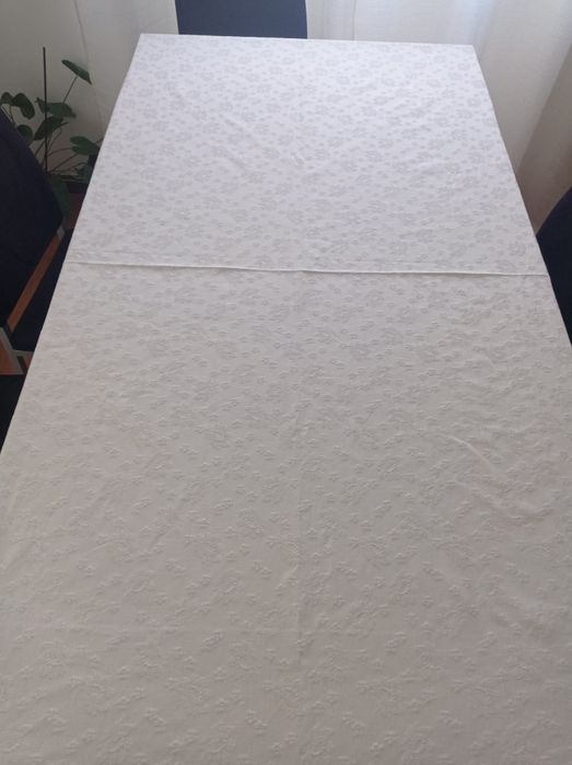 Toalha de mesa branca com motivos florais em destaque