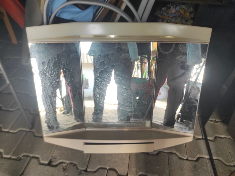 Wisząca szafka łazienkowa z lustramii szufladkami.