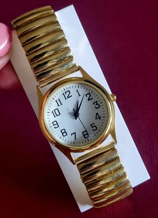 Relógio dourado, elástico, com mostrador em aço.