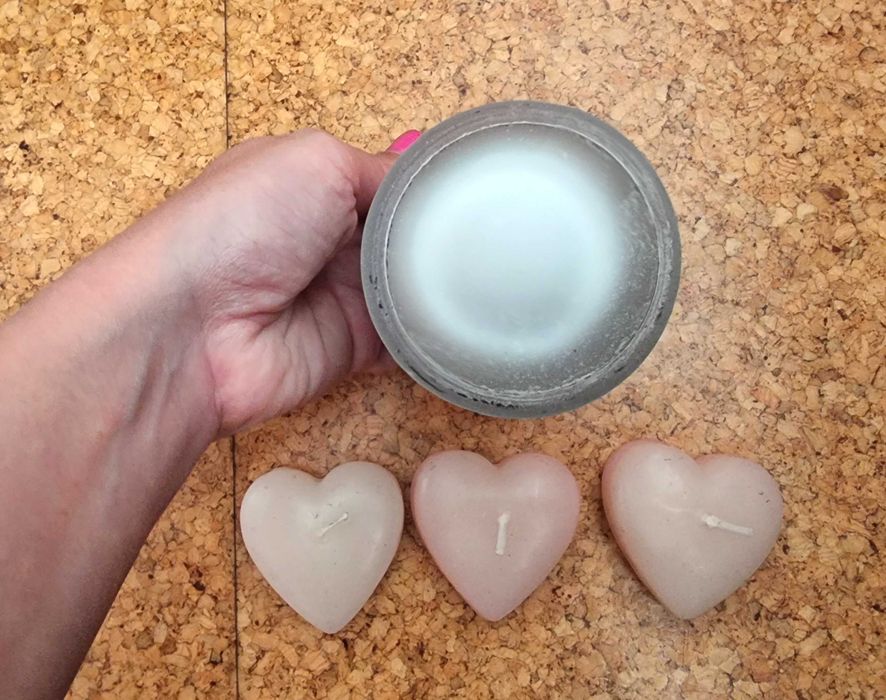 Copo em tons de rosa com três velas em formato de coração