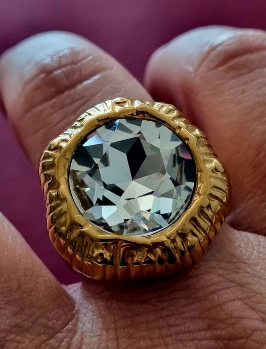 Anel dourado, em aço, com grande ponto de luz. T18