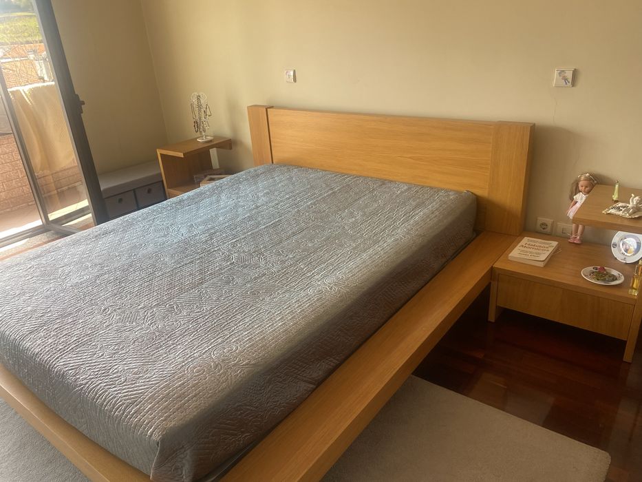 Quarto com cama de casal, colchao e mesinhas de cabeceira
