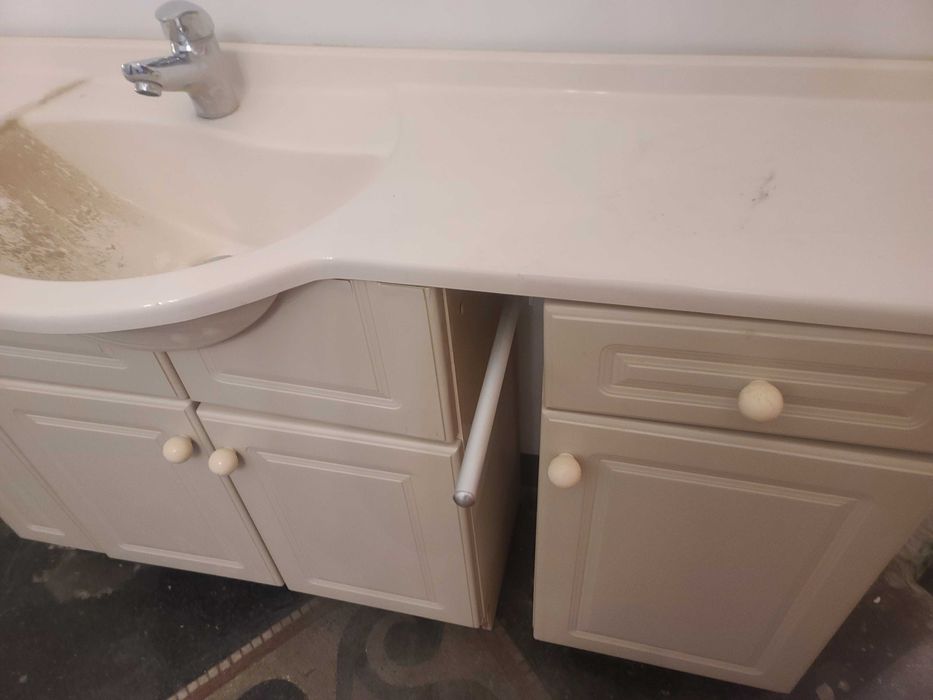 Szafka łazienkowa z umywalka i baterią.