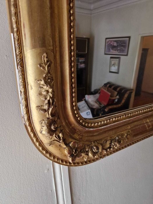 Grande espelho de parede antigo, com uma moldura dourada ornamentada de estilo clássico