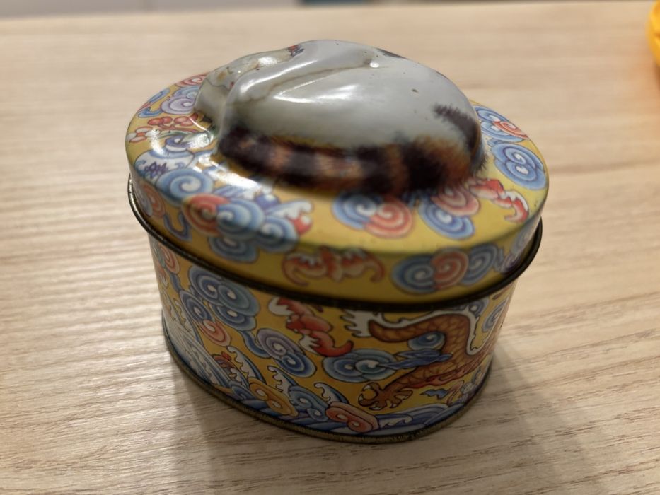 Caixa de lata oval, com gato em relevo