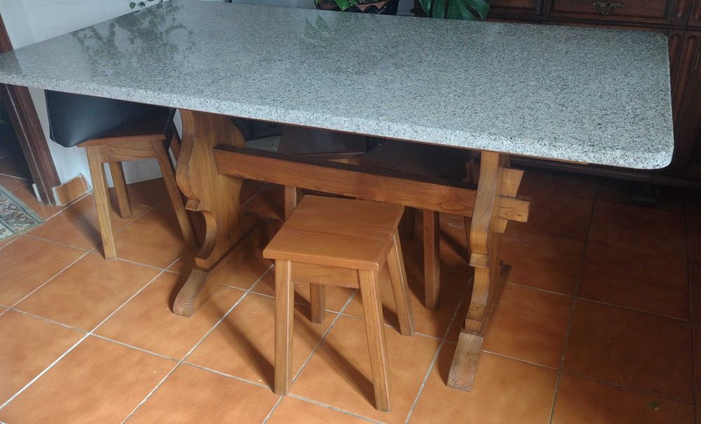 Mesa de pedra com 4 bancos.