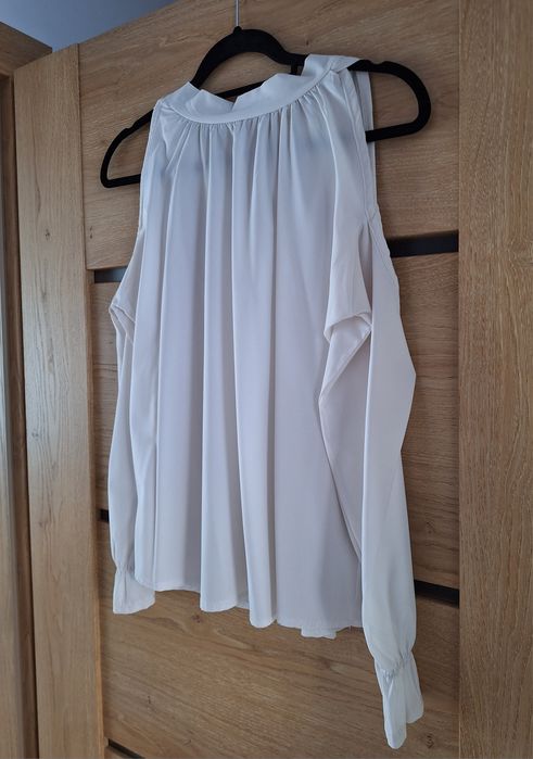 Biała bluzka z wycięciem na ramiona i ozdobnym wiązaniem na tyle