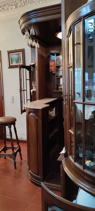 Bar de canto com vidros facetados, balcão, vitrines e 2 bancos