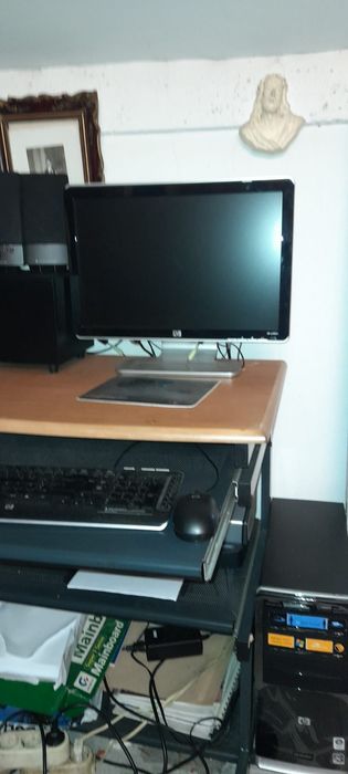 Computador HP, impressora, sistema de som e secretária.