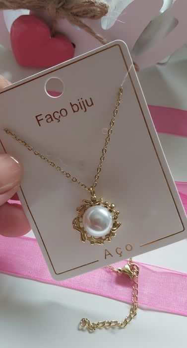 Colar dourado, em aço, com pérola. Tem extensor