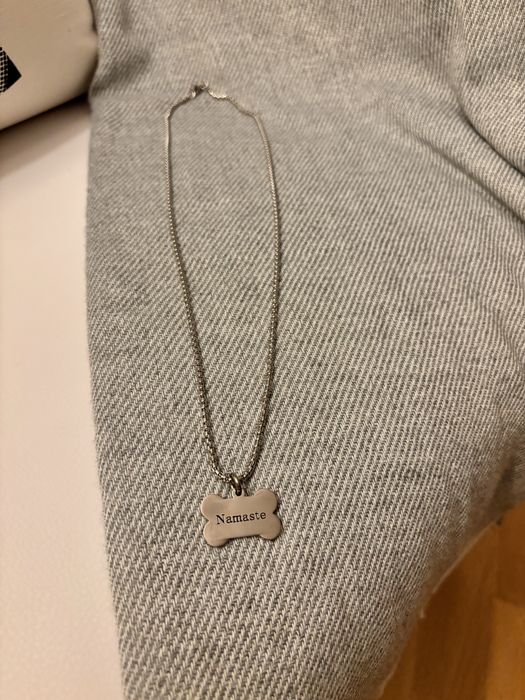 Fio prateado com pendente em forma de osso