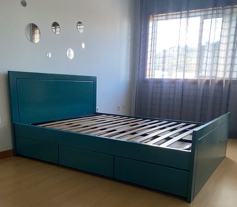Cama em madeira de castanho pintada em azul a ver o veio da madeira