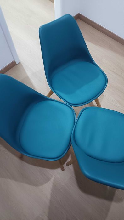 Cadeiras azul petróleo com penas em madeira