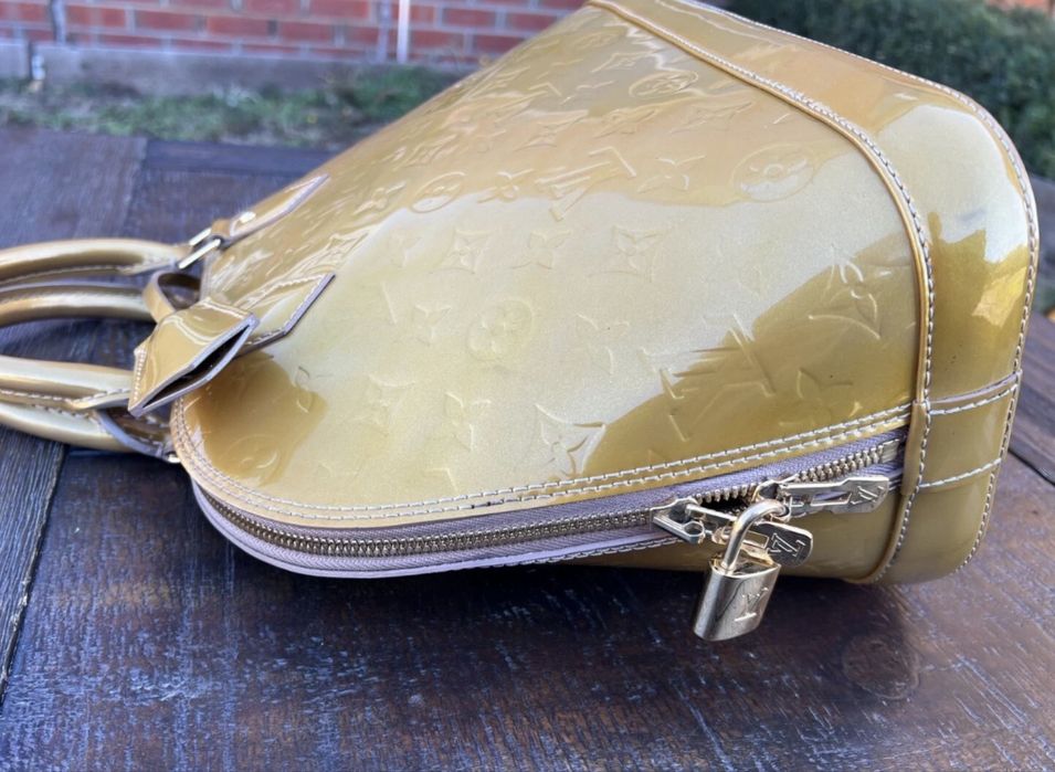 Mala  bolsa Louis Vuitton Alma PM dourada