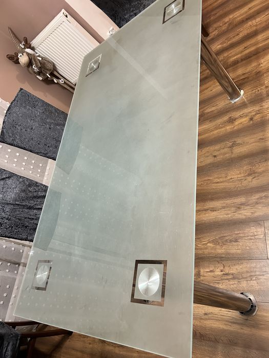 Szklany stół z metalowymi nogami