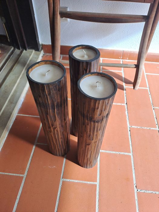 3 velas altas em tronco de madeira