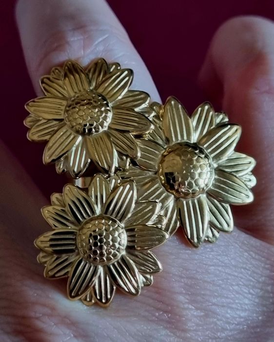 Anel dourado, em aço, formato de 3 lindas flores. Ajustável