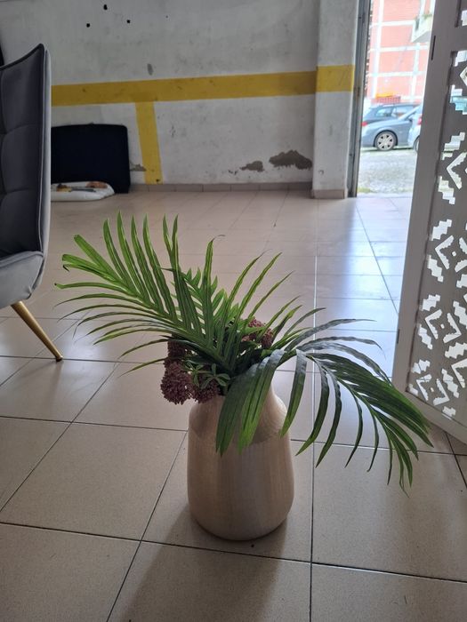 Vaso dourado com planta artificial