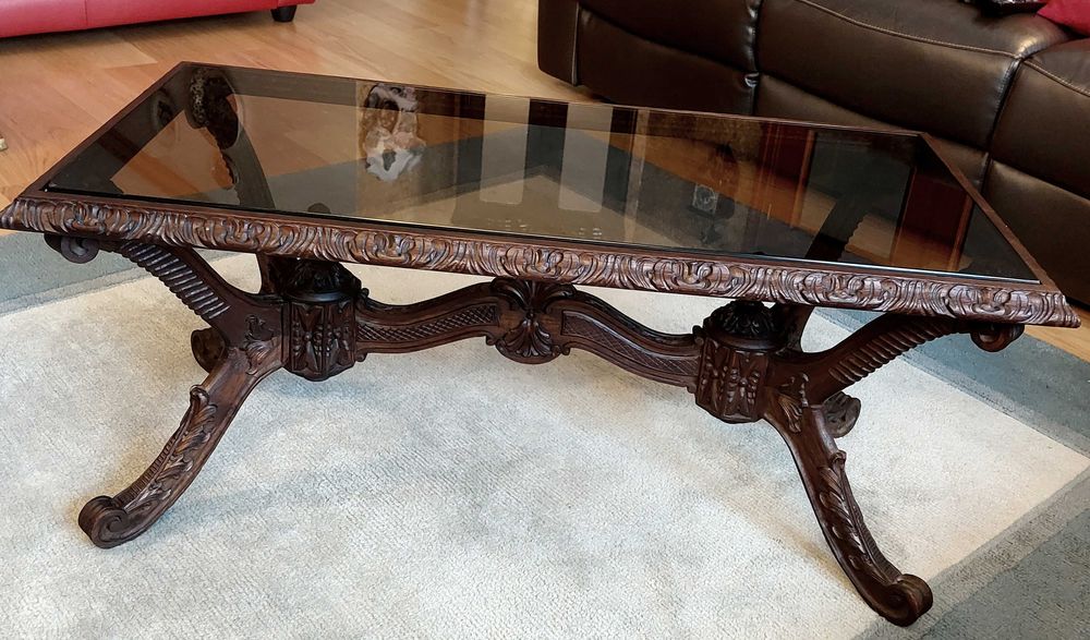 Mesa baixa de centro em madeira finamente entalhada, tampo em vidro.