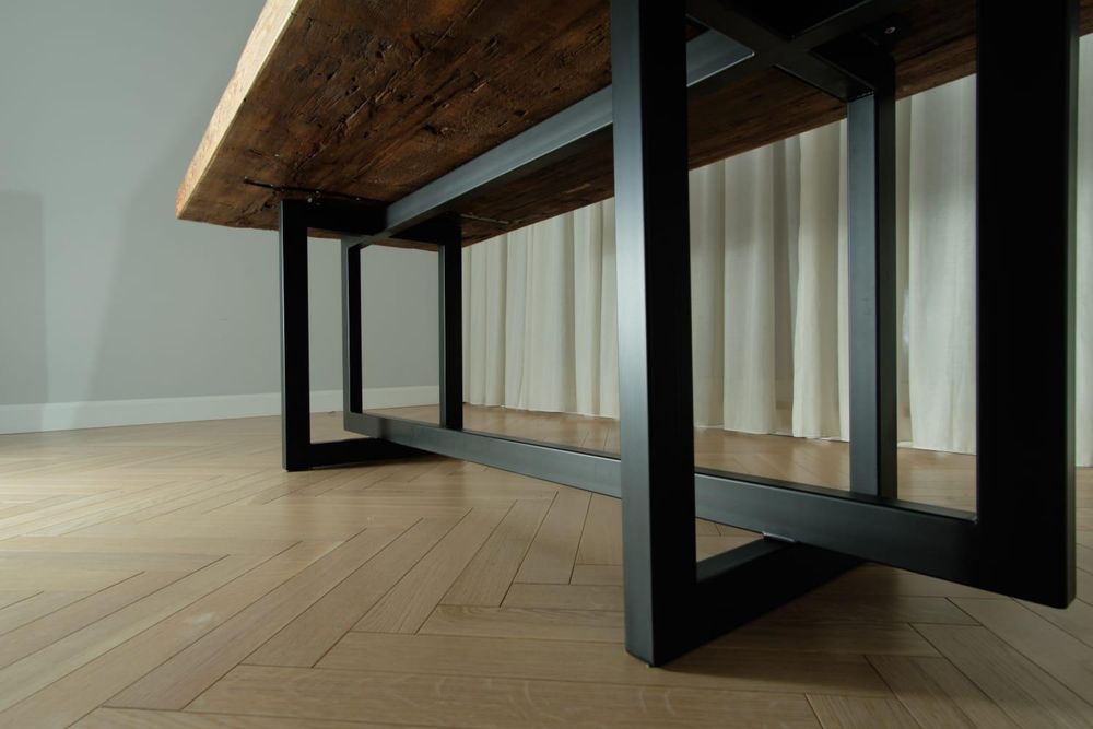 Stół drewniany z metalową podstawą.
