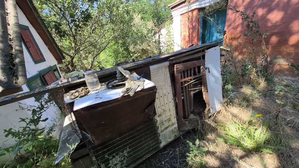 Будинок з джерельною водою на березі річки, асфальтована дорога