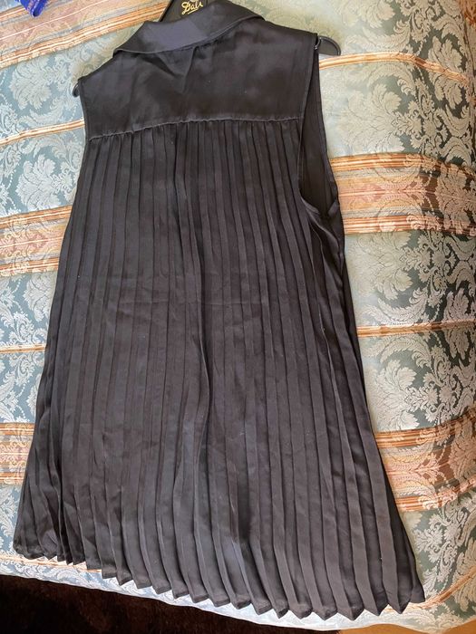 Túnica preta com elegante plissado na parte de trás