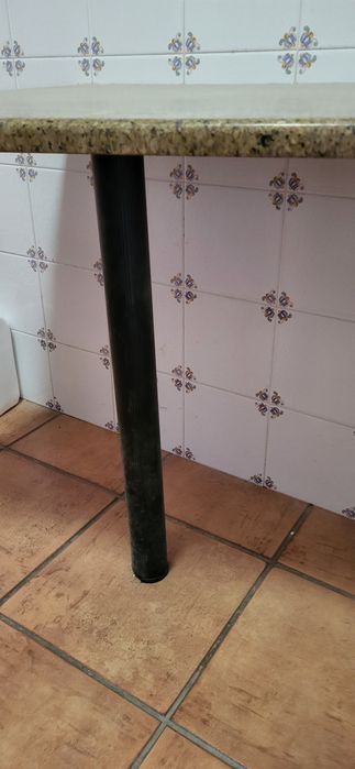 Mesa em pedra  com pé para fixar à parede.
