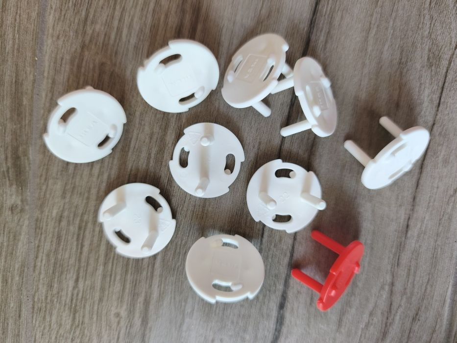9 Protetores p/tomadas, branco e 1 vermelho (chave)