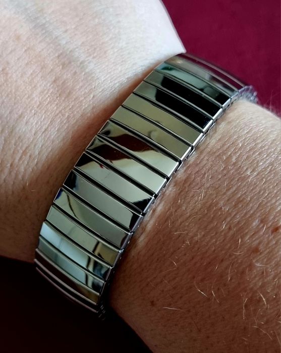 Pulseira elástica prateada, em aço inoxidável.