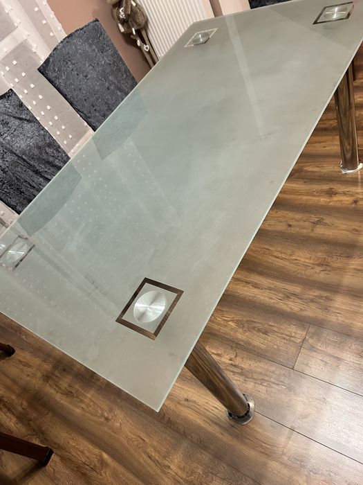 Szklany stół z metalowymi nogami