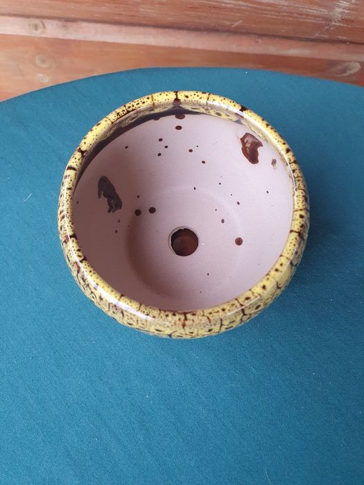 Żółta doniczka ceramiczna z przytwierdzoną podstawką