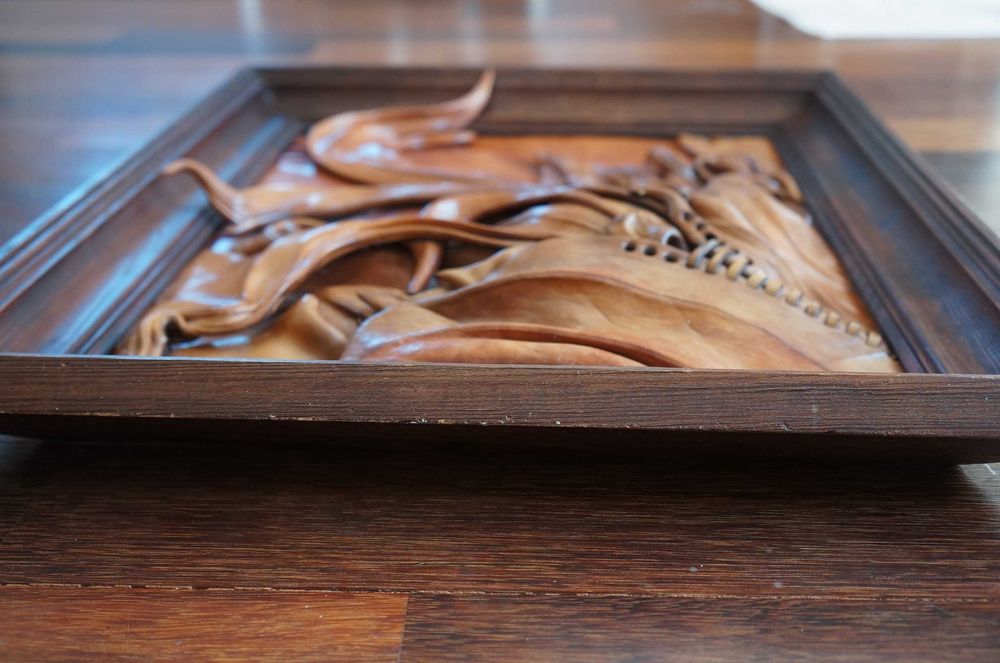 Obraz ze skóry w drewnianej ramie.