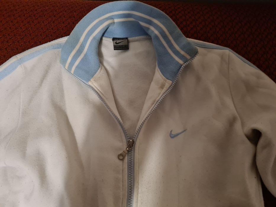 Bluza Nike biała z niebieskimi paskami.