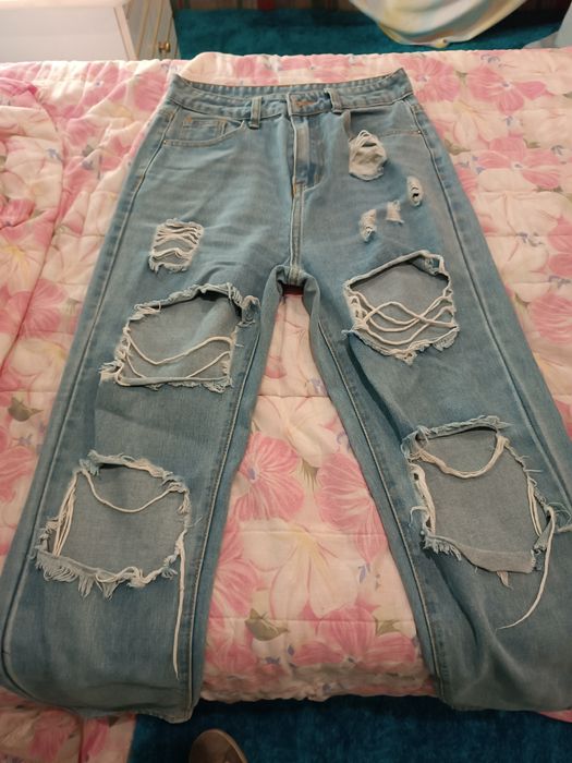 Calças de ganga mais ou menos skinny e rasgadas.