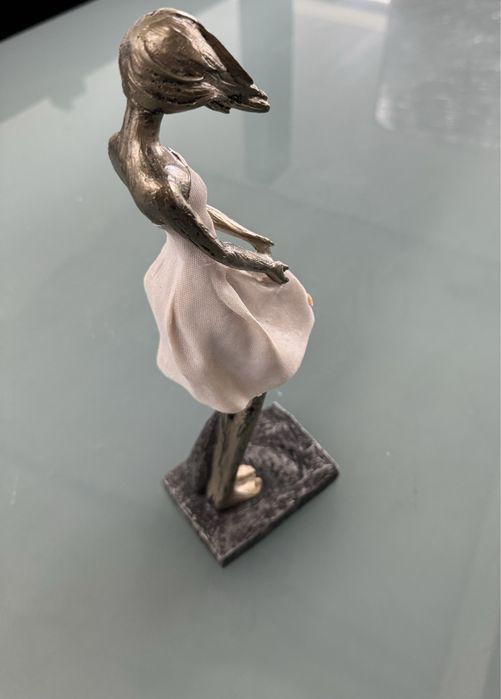 Peça decorativs em formato de mulher com o cabelo a fugir com o vento.