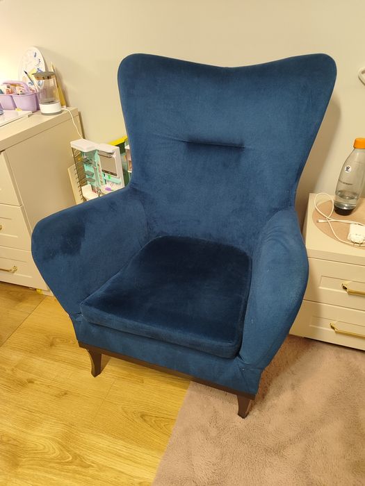 fotel uszak z aksamitnym obiciem w kolorze granatowym.