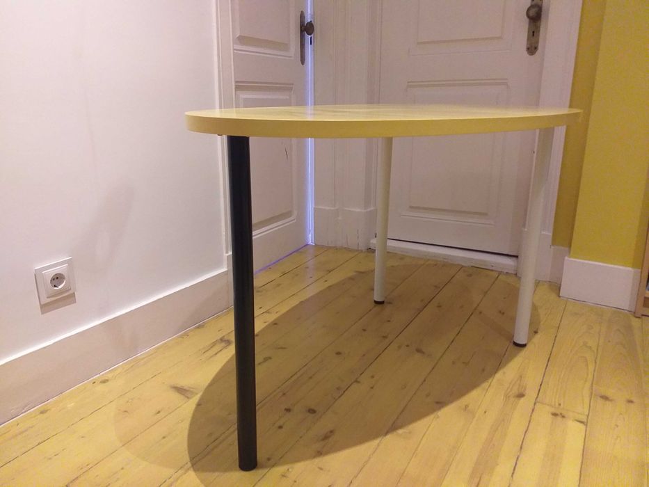 Mesa design oval com cor amarela, uso versátil.