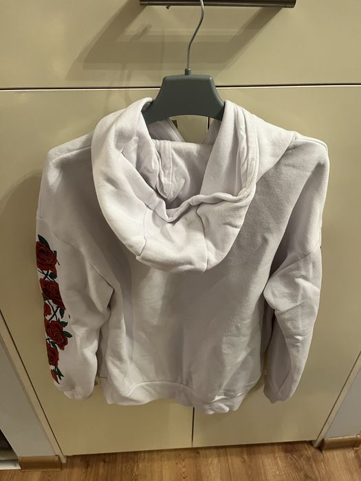 białą bluzę z pięknymi czerwonymi różami na rękawach