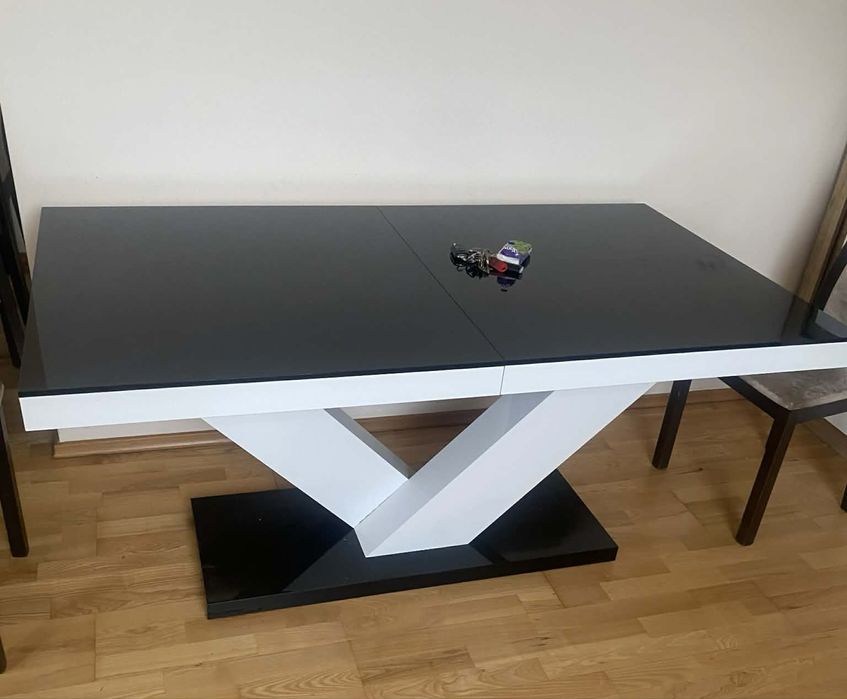Nowoczesny rozkładany stół z czarnym blatem i geometryczną podstawą