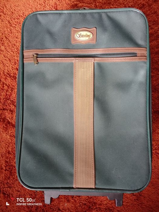 Mala de viagem em estado razoável tem algumas marcas de uso.