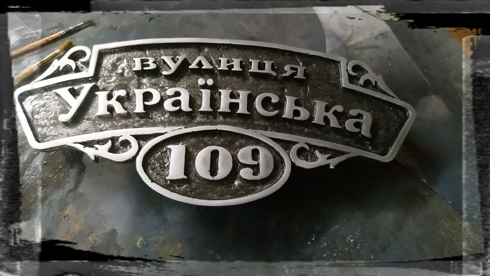 Табличка з адресою на будинок. Адресна табличка вилита з металу.